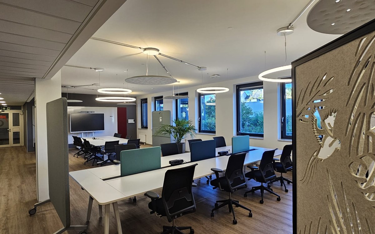 Büroetage mit großen Ringleuchten über den Arbeitsplatzreihen