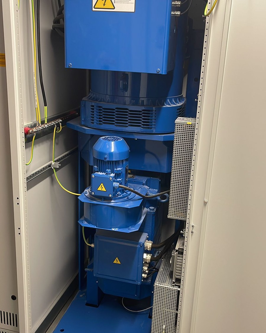 Blauer Generator im geöffneten Technikschrank